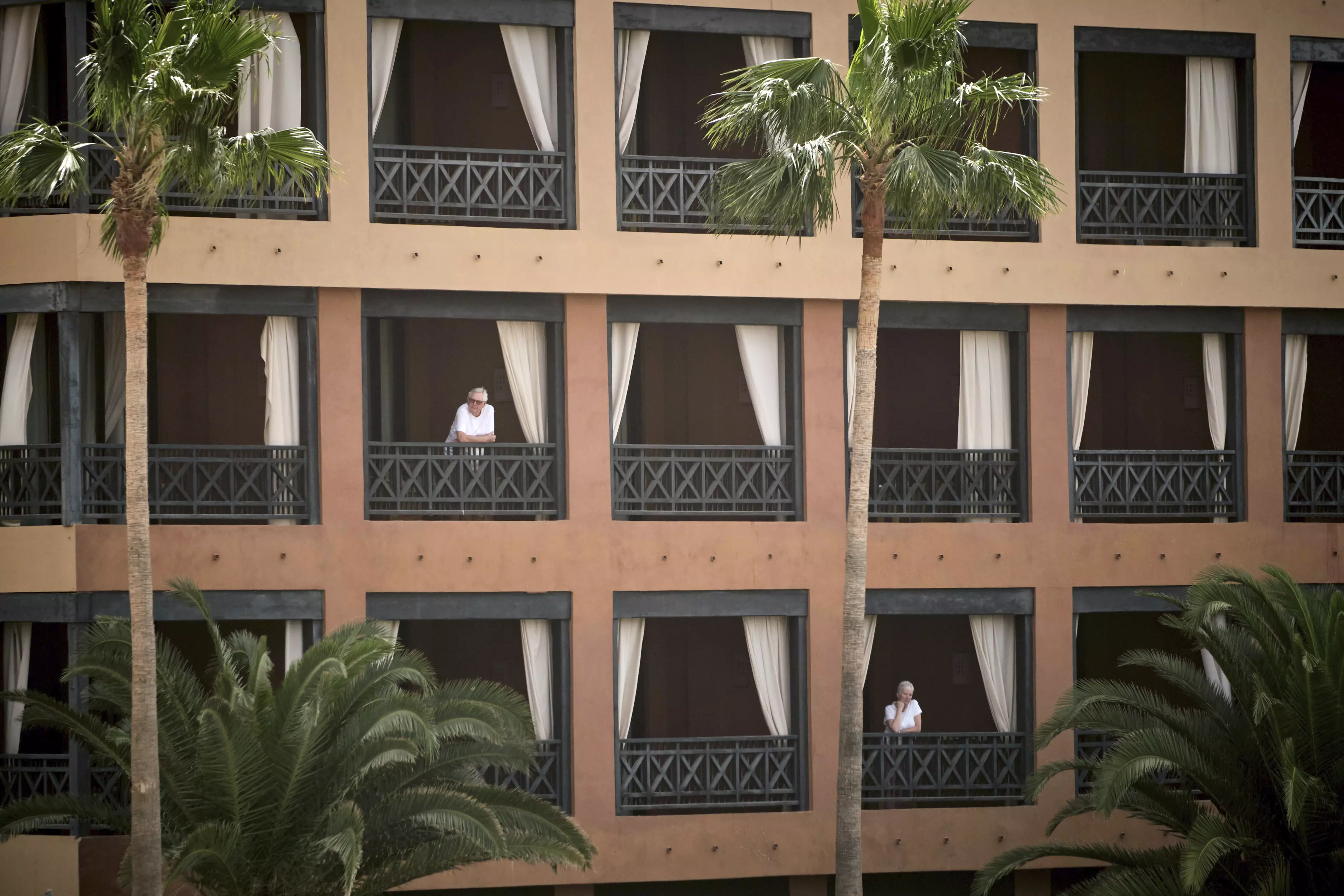 People stand at their balconies at the H10 Costa Adeje Palace hotel in Tenerife.