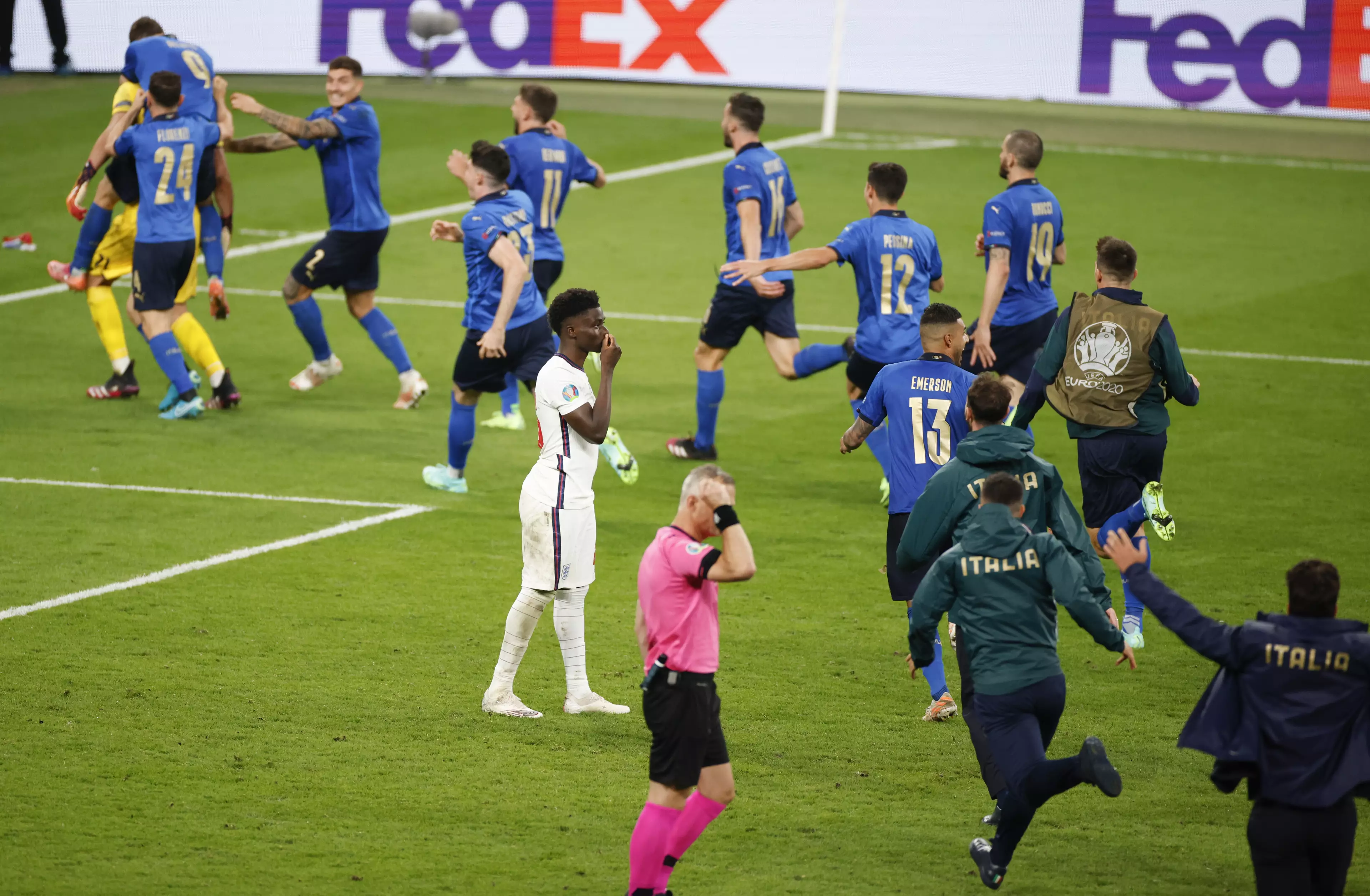 Italy players run past Saka to celebrate after his saved penalty. Image: PA Images