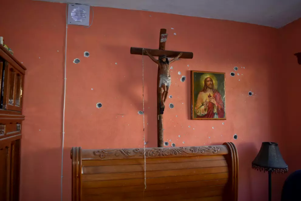 The wall of a home also riddled with bullets.