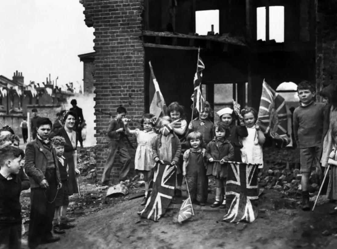 Londoners celebrating VE-Day in 1945 amid the ruins of their home.