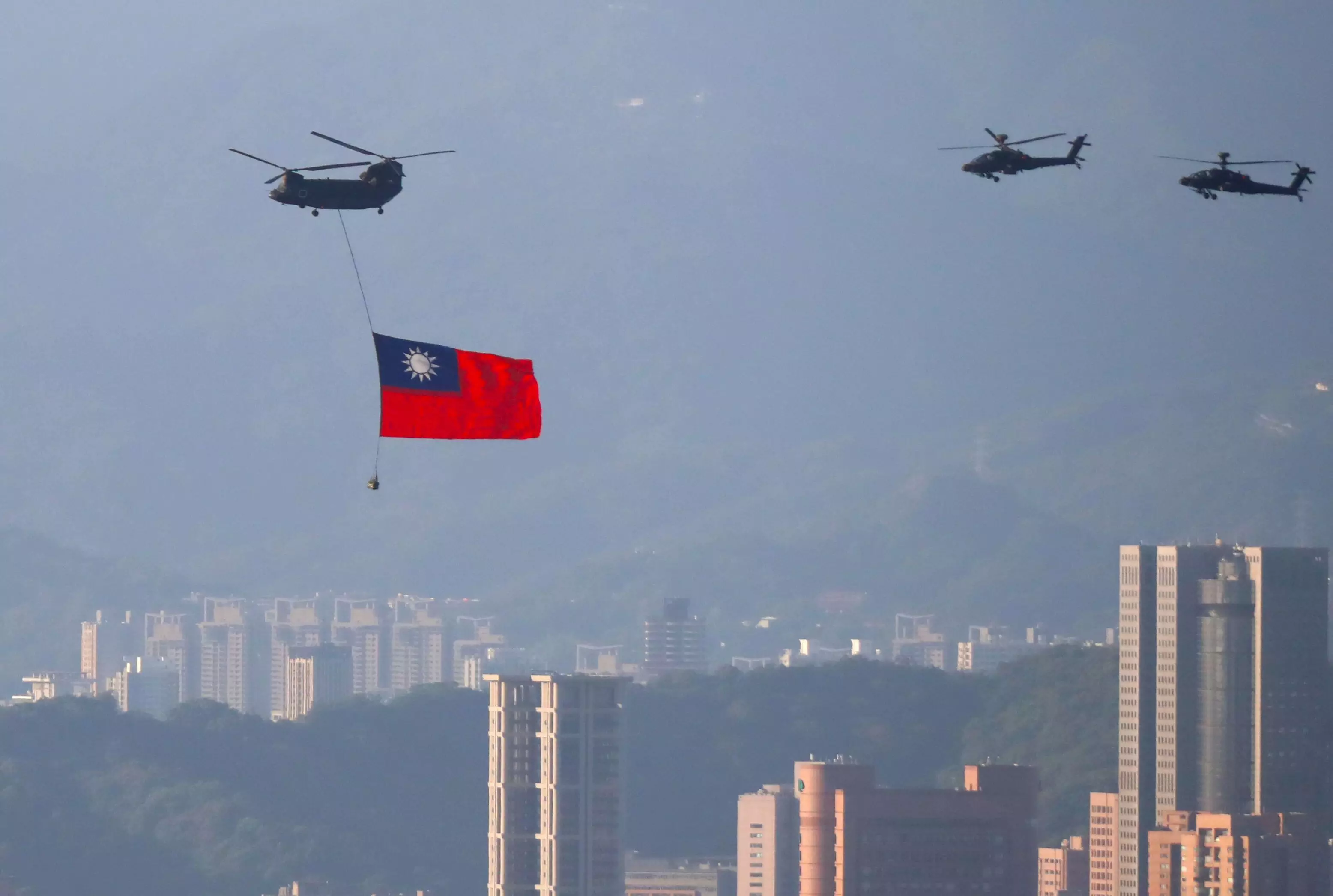 A military helicopter carrying a Taiwan flag conducts a flyby rehearsal ahead of the Double-tenth national day celebration.