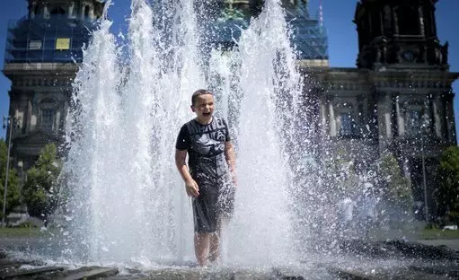 A boy refreshes in a fountain in Berlin, Germany, Sunday, June 30, 2019.