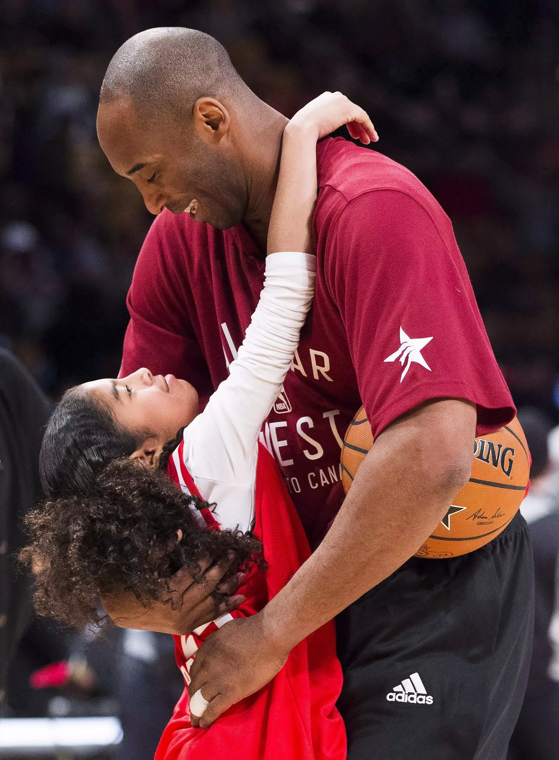Kobe Bryant hugs his daughter Gianna on the court.