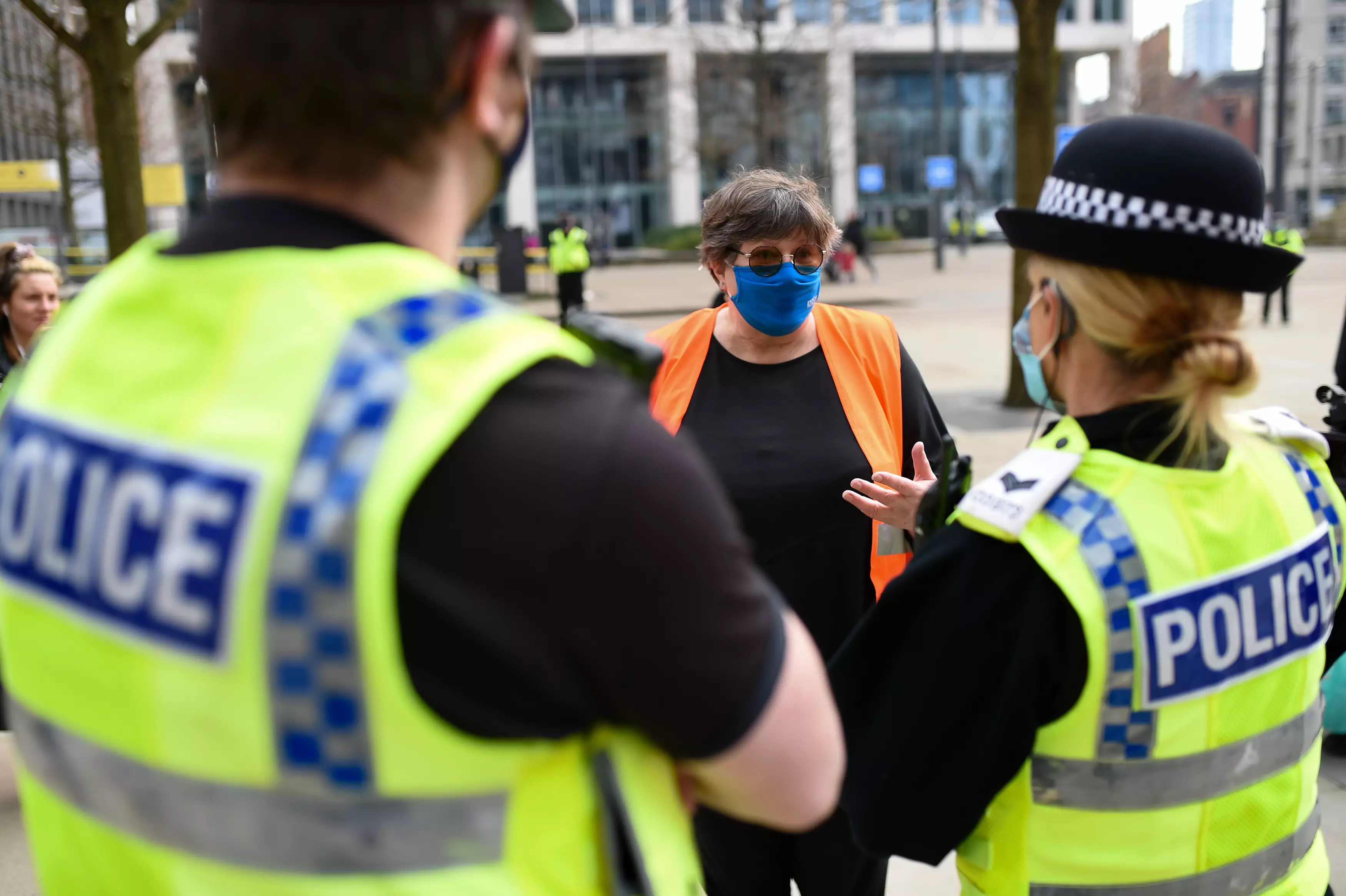 Police speak to NHS worker Karen Reissmann after breaking up the protest in Manchester.