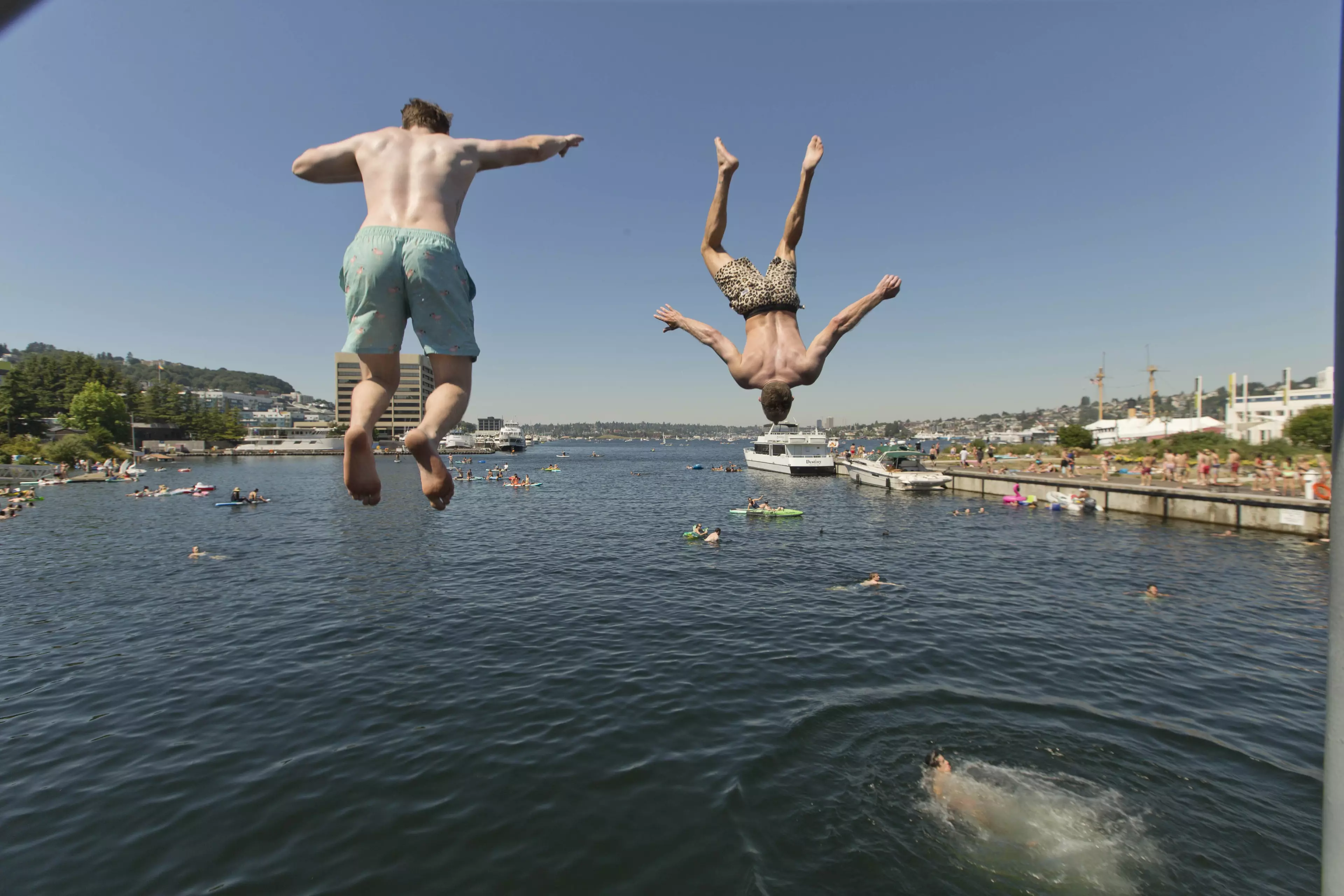 Two people jump from a pedestrian bridge at Lake Union Park, Seattle.