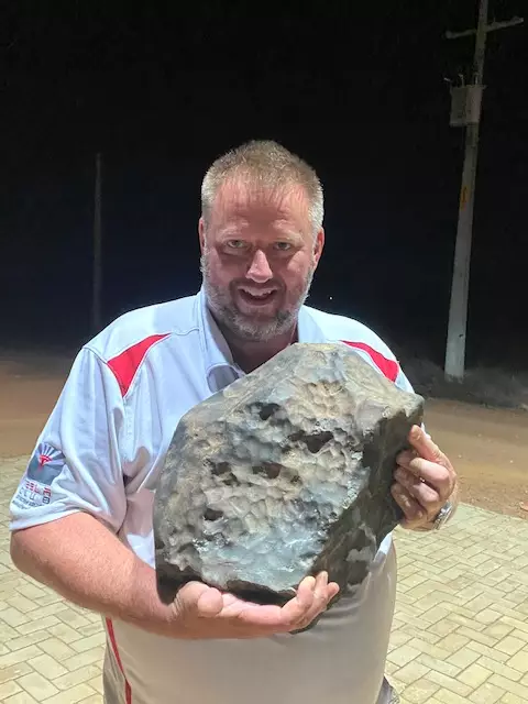 Michael Farmer holding the 38.2kg piece of meteorite.