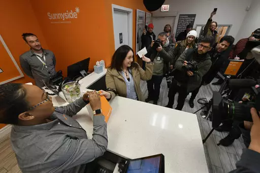 Jackie Ryan of Forest Park, Ill., becomes the first person in Illinois to purchase recreational marijuana.