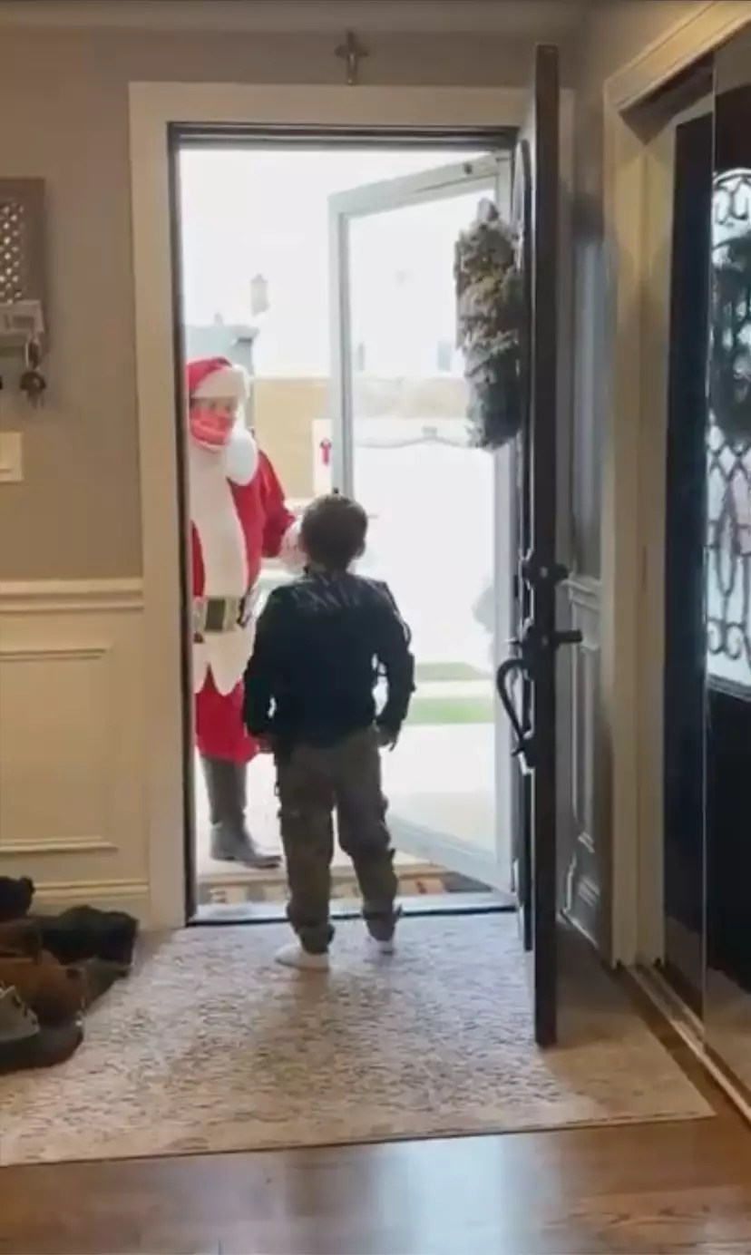 A different Santa visits Michael at his home with a gift (