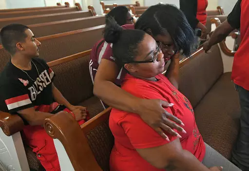 Shevona Overton, seated, gets a hug from her aunt Jennifer Overton during a news conference.