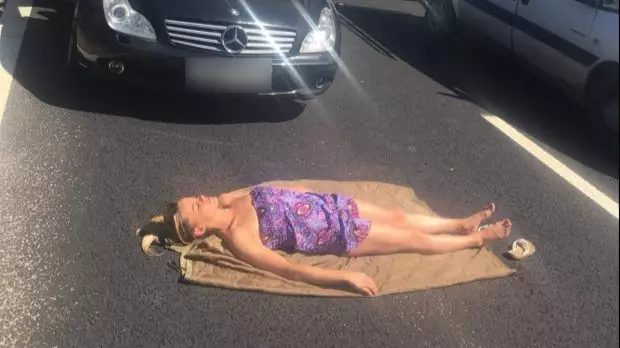 Woman Takes Advantage Of Traffic Jam To Indulge In A Spot Of Sunbathing