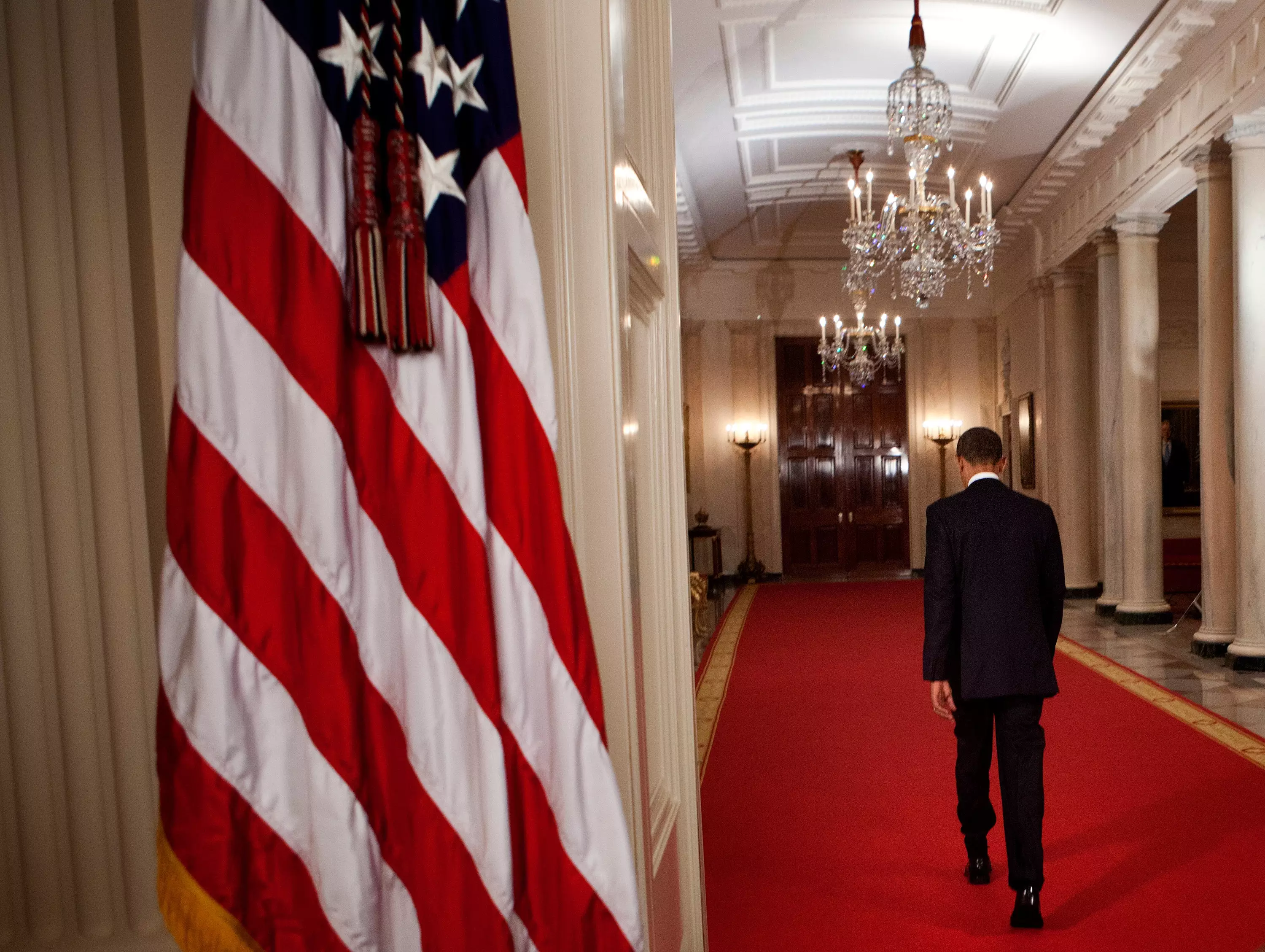 President Obama walks through the Cross Hall of the White House after sharing the news on 2 May 2011.