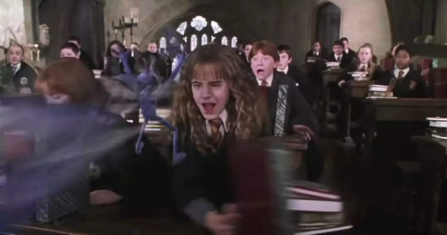 Hermione quickly shoves her books off the table (