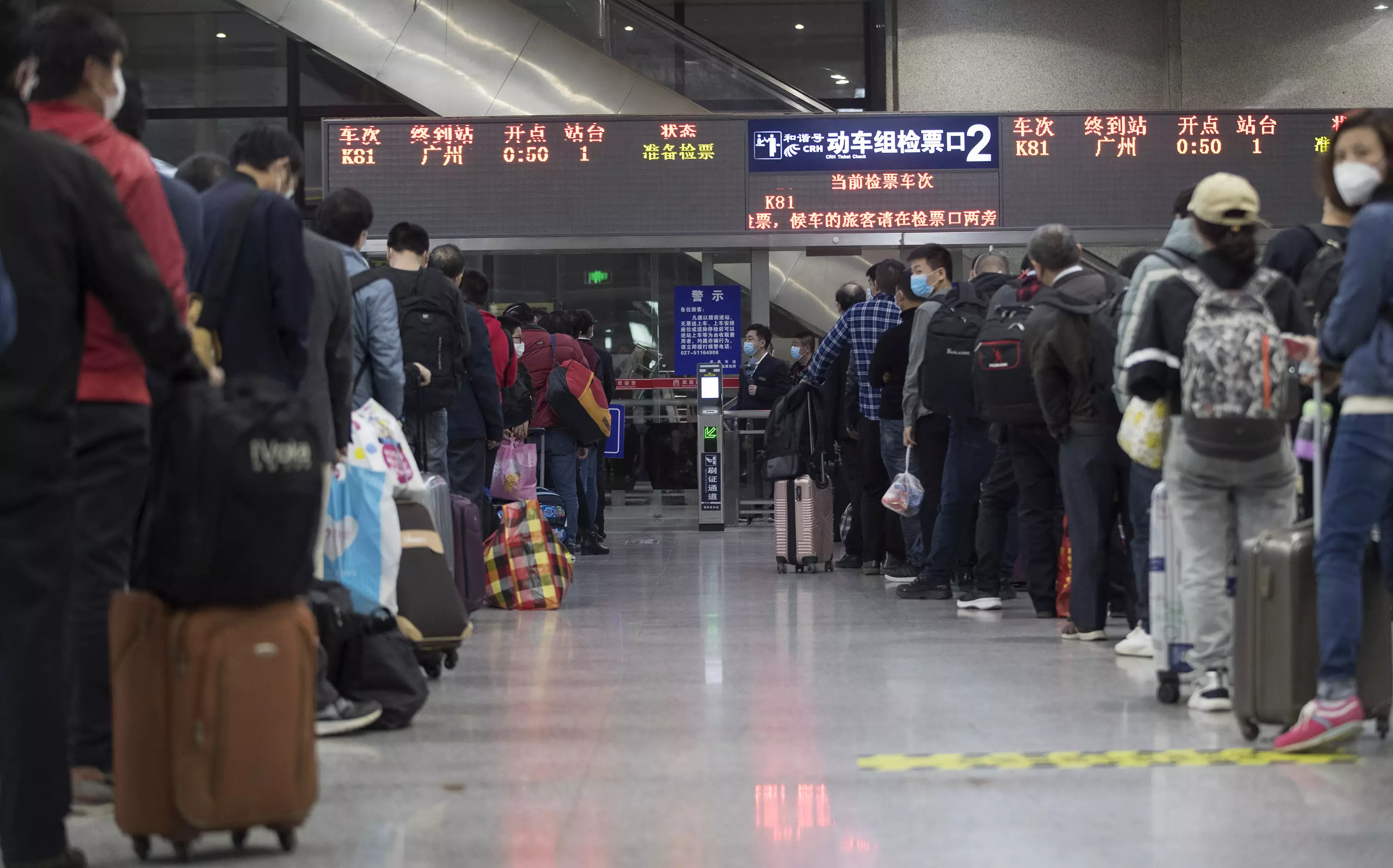 Passengers wait in line for train K81 at Wuchang Railway Station in Wuhan.