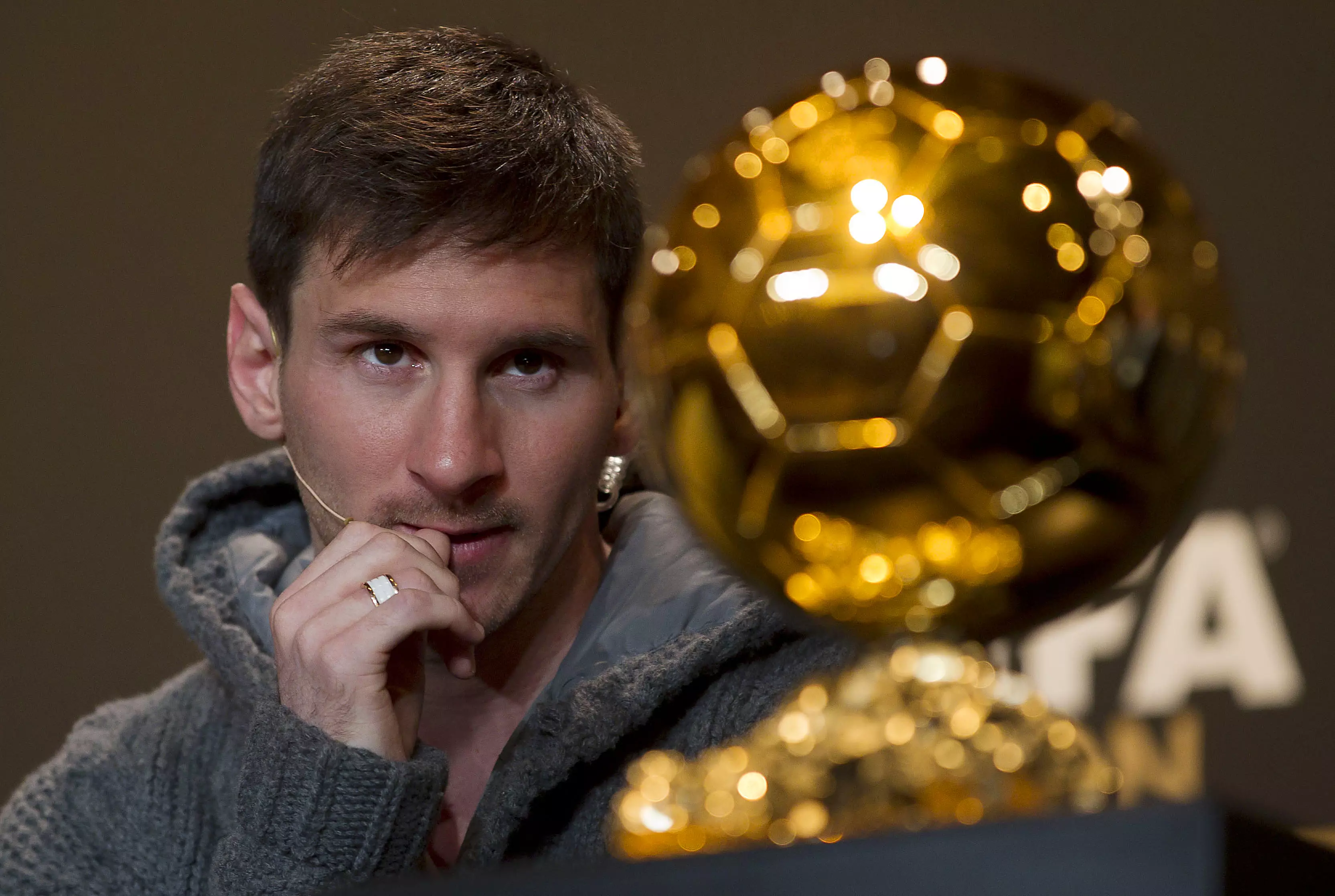 Messi looks lovingly at the award. Image: PA Images