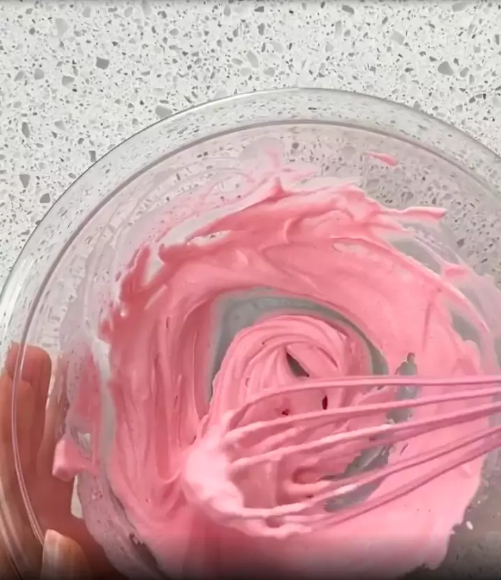 Speedily mix together the Strawberry Nesquik and whipping cream for a cloud-like result (
