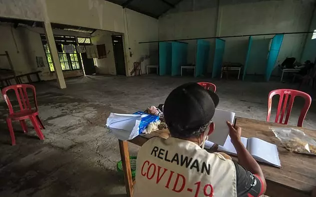 A volunteer at one of the abandoned houses repurposed as quarantine facilities in at Sepat village in Sragen, Central Java.