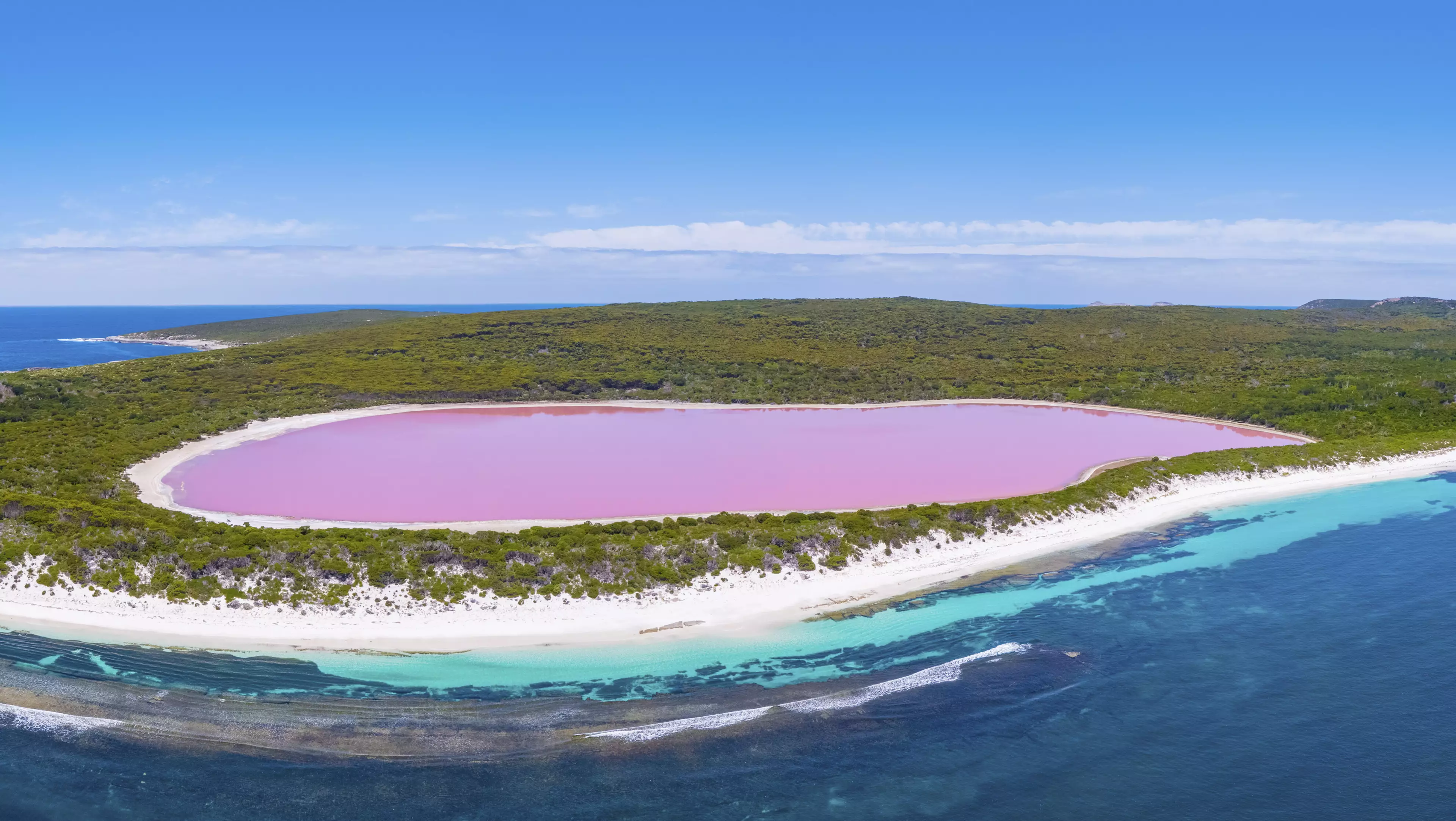 Lake Hillier is next to the dark blue waters of the Indian Ocean (