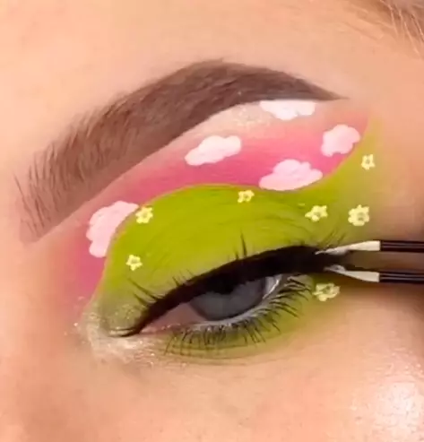 Next, she paints on tiny clouds and flowers before finishing with mascara and lashes (