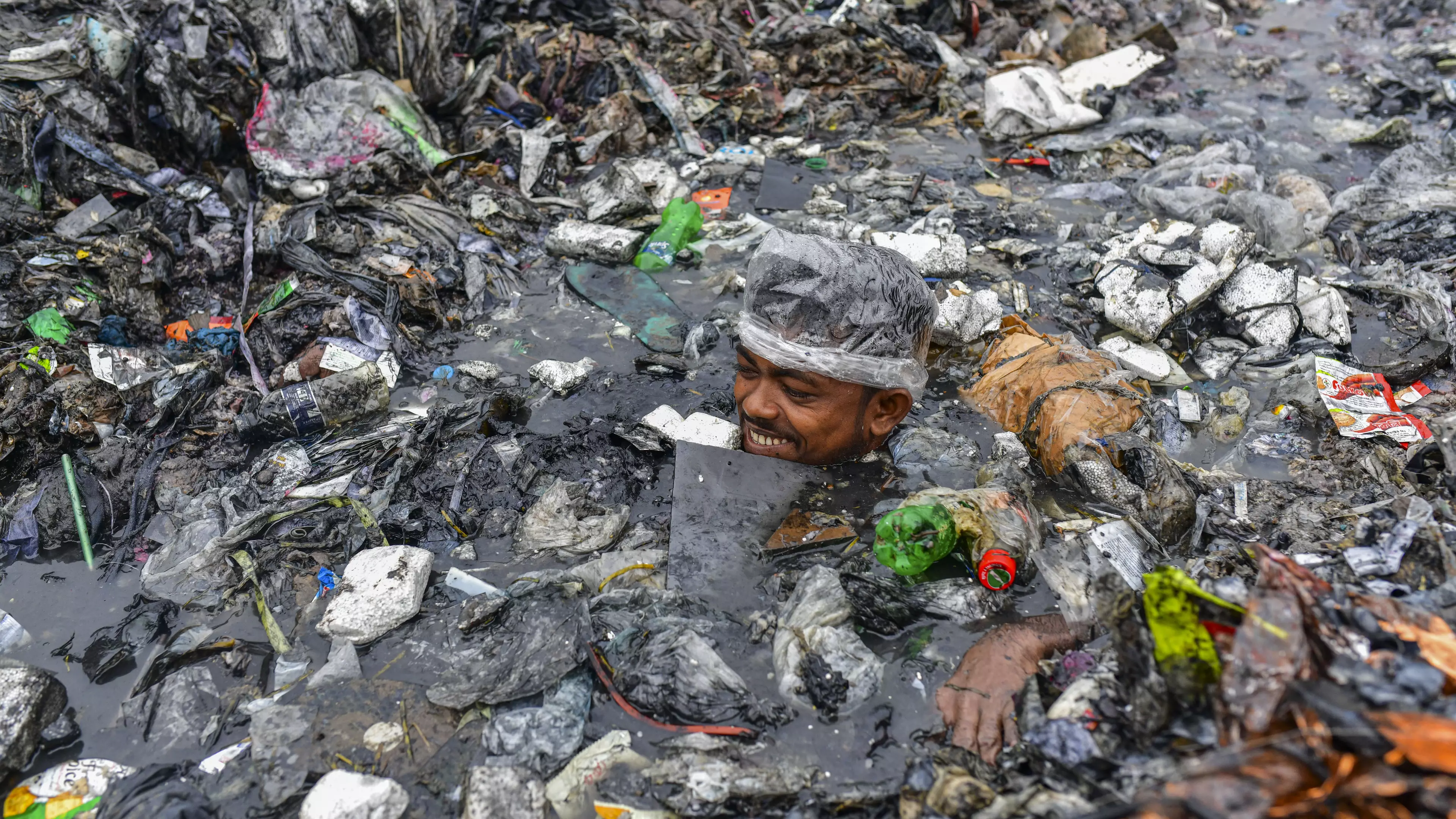 Bangladesh Street Cleaners Wearing Just Plastic Hats As PPE Swim Up To Their Necks In Rubbish
