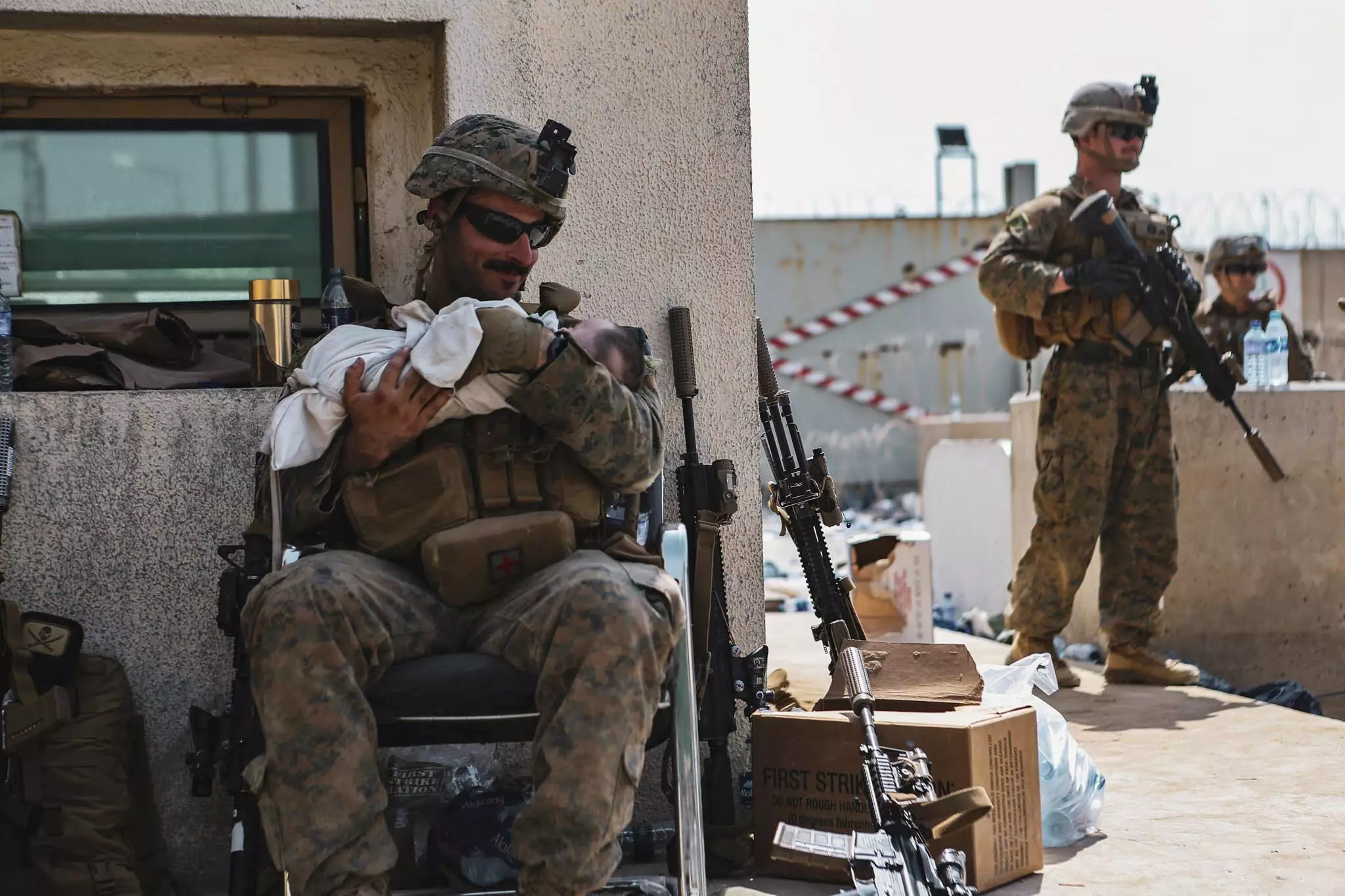 A Marine assigned to the 24th Marine Expeditionary Unit (MEU) calms an infant during an evacuation at Hamid Karzai International Airport, Kabul.