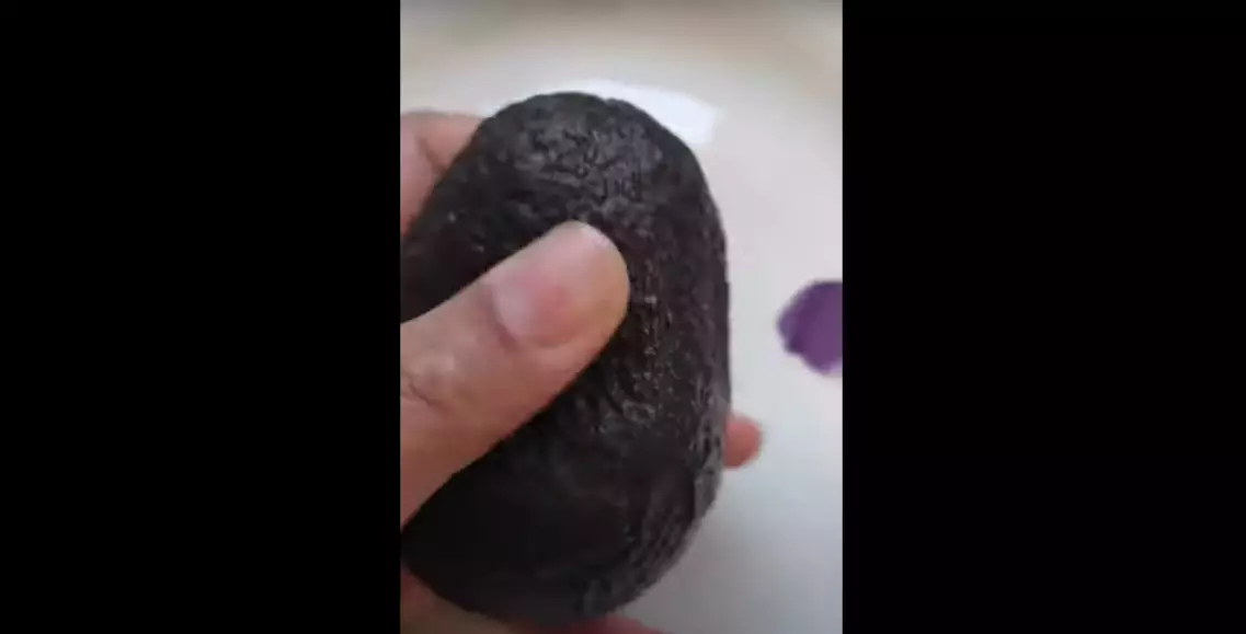 The clever hack begins by showing the Youtuber gently squeezing around the avocado (