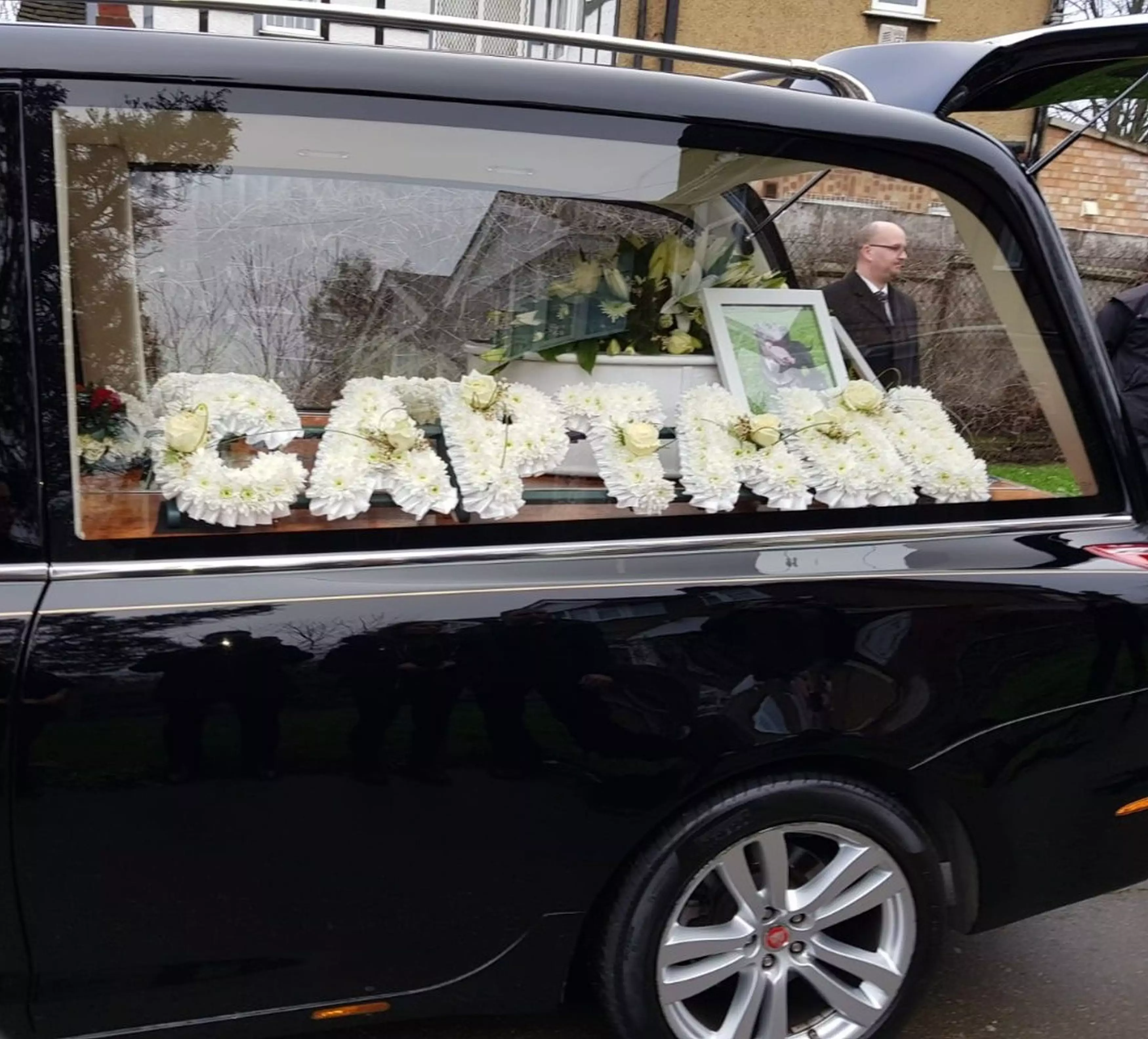 Some of the floral tributes with the coffin in the limousine.