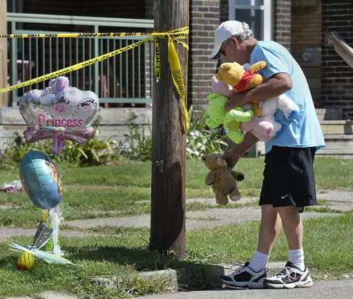 Paul Laughlin, 57, places stuffed animals on Sunday, Aug. 11, 2019 outside the location of the early morning fire.