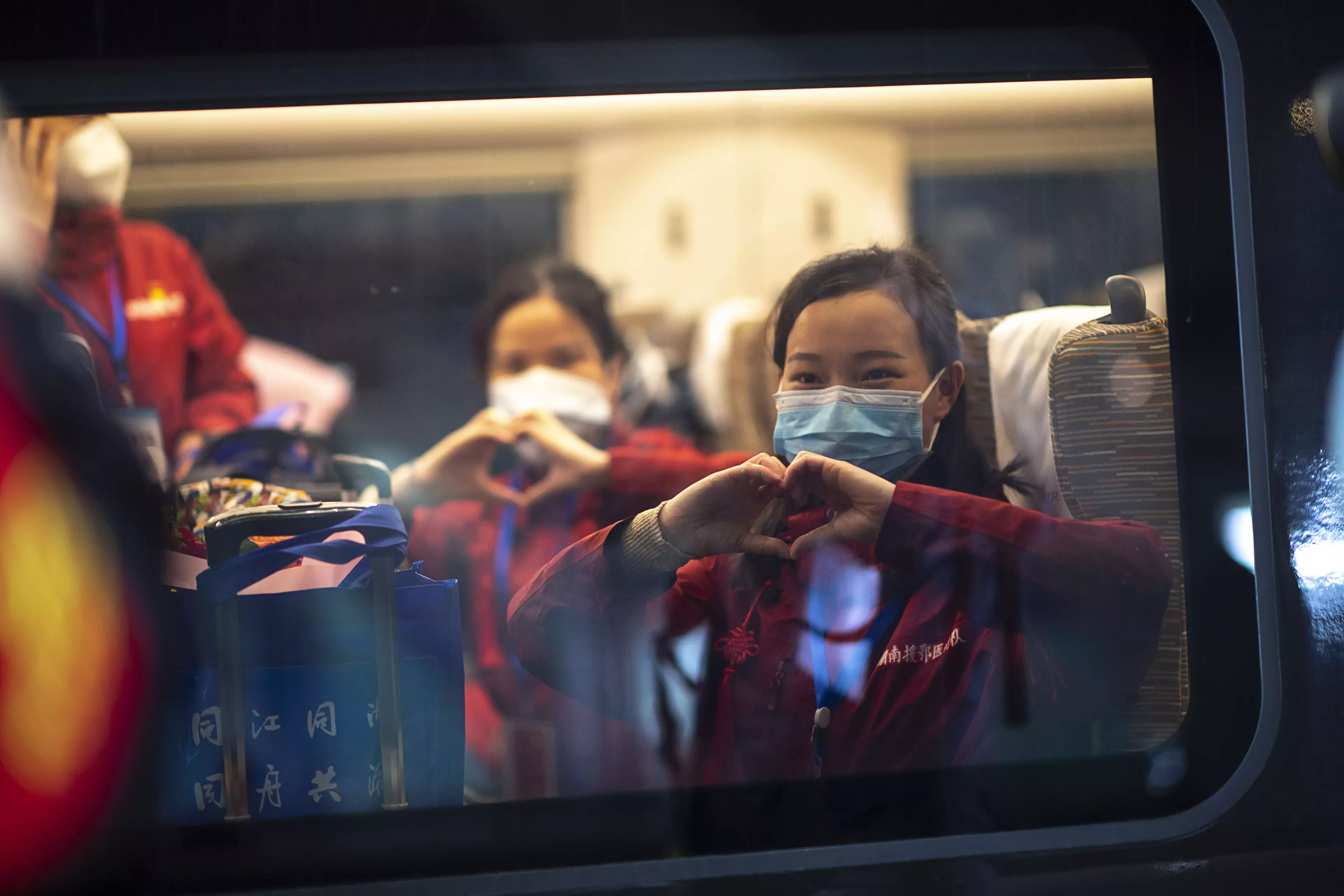 Medical staff from Hunan gesture on the train at a railway station in Wuhan.