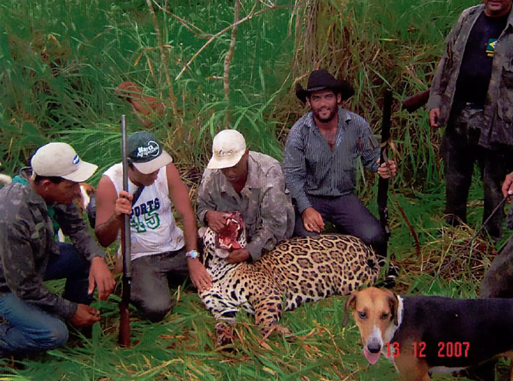 The poachers with a killed jaguar.