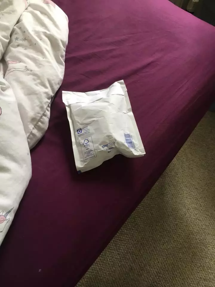 The parcel was successfully thrown through the window and onto the bed.