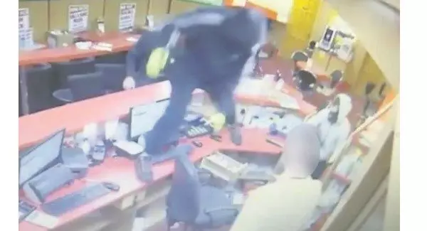 One robber vaulted the counter with a hammer
