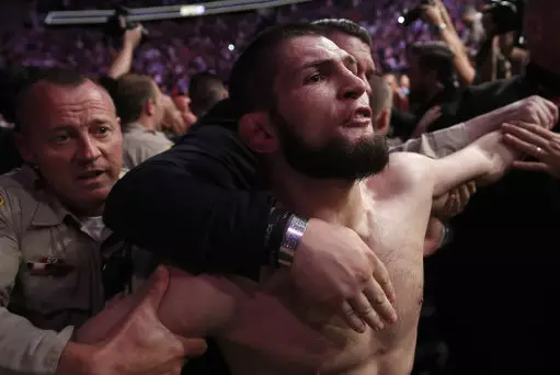 Khabib held back by security after victory.