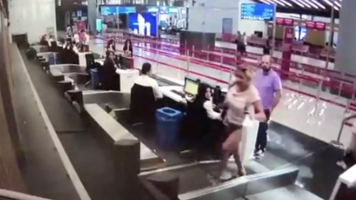 Woman Stands On Baggage Conveyor Belt At Airport And Immediately Stacks It