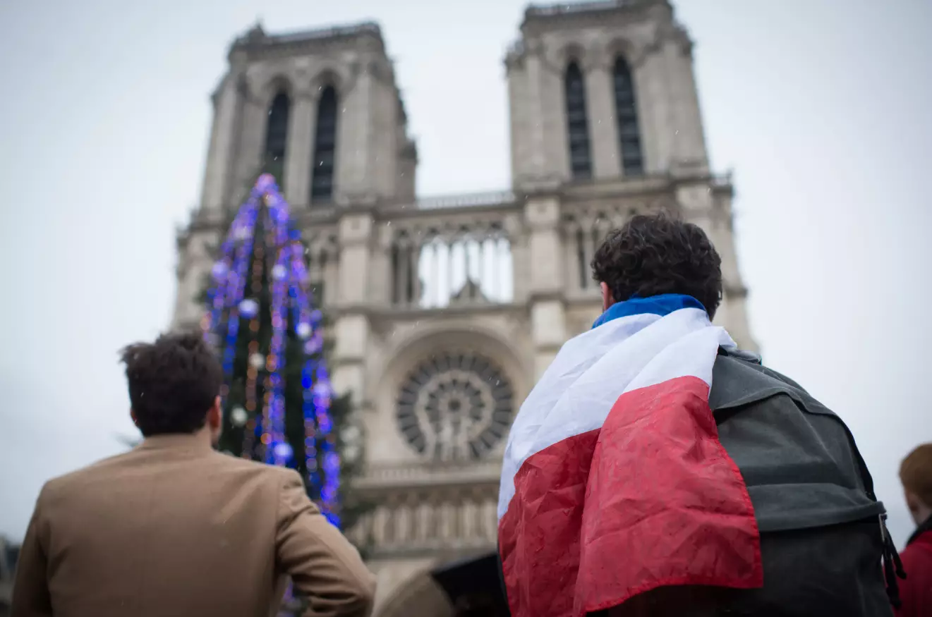 People standing in front of Notre-Dame to observe a minute of silence for the victims of an attack by armed gunmen at the offices of French satirical newspaper Charlie Hebdo in Paris.