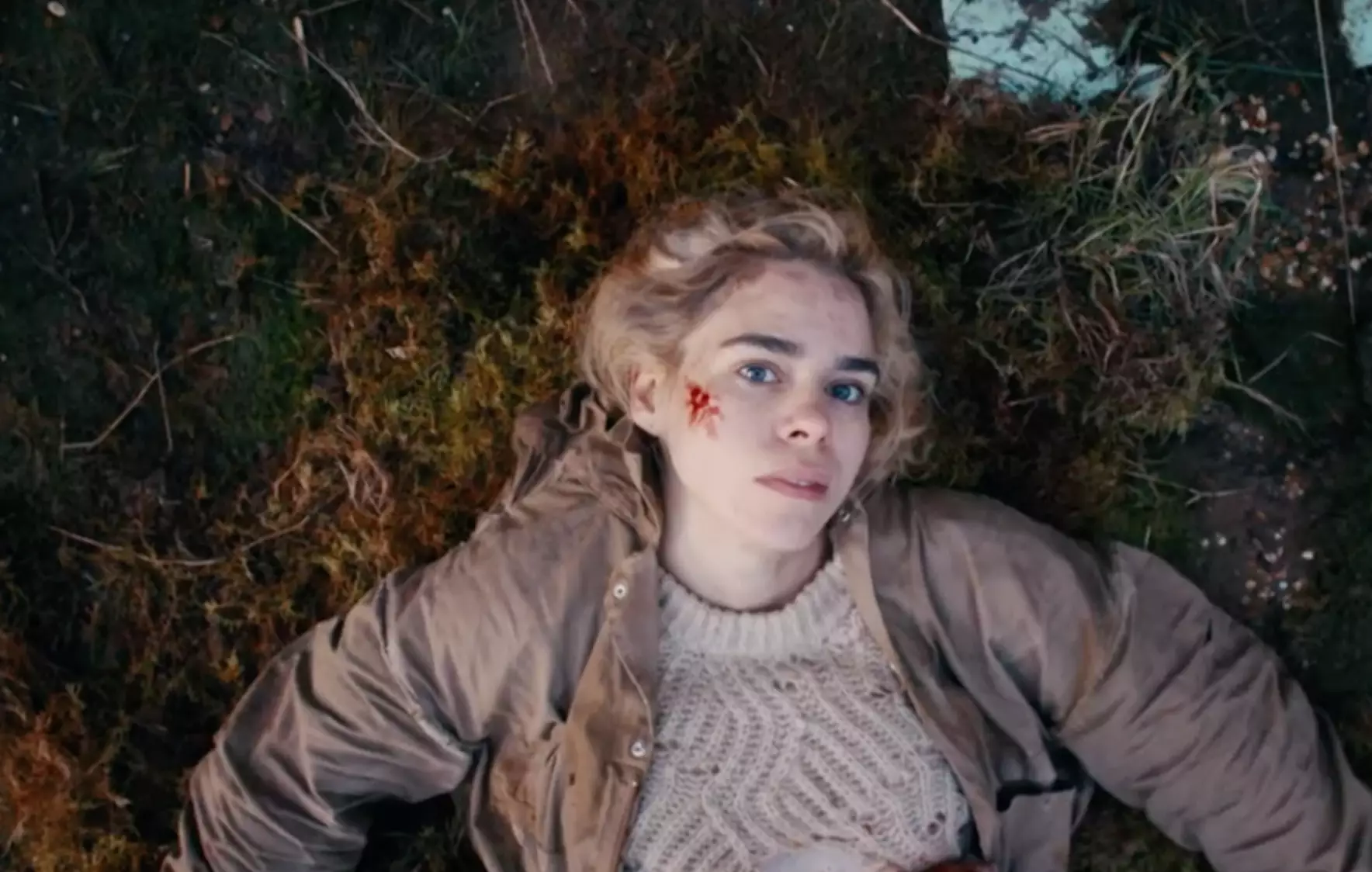 We see Suzie laying bloody in a field in the disturbing trailer (
