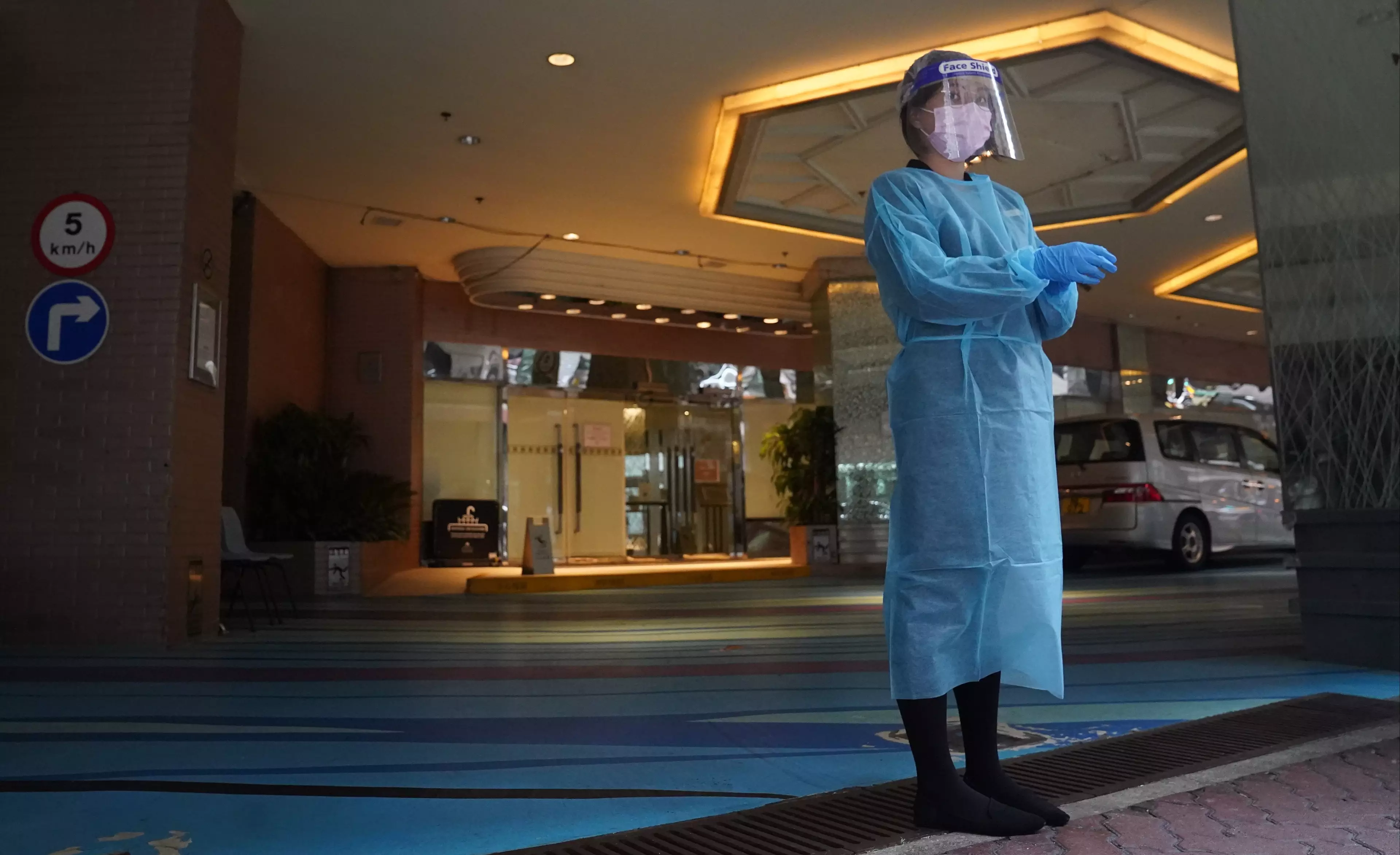 A healthcare worker in Hong Kong ready to accept new arrivals at hotel quarantine.