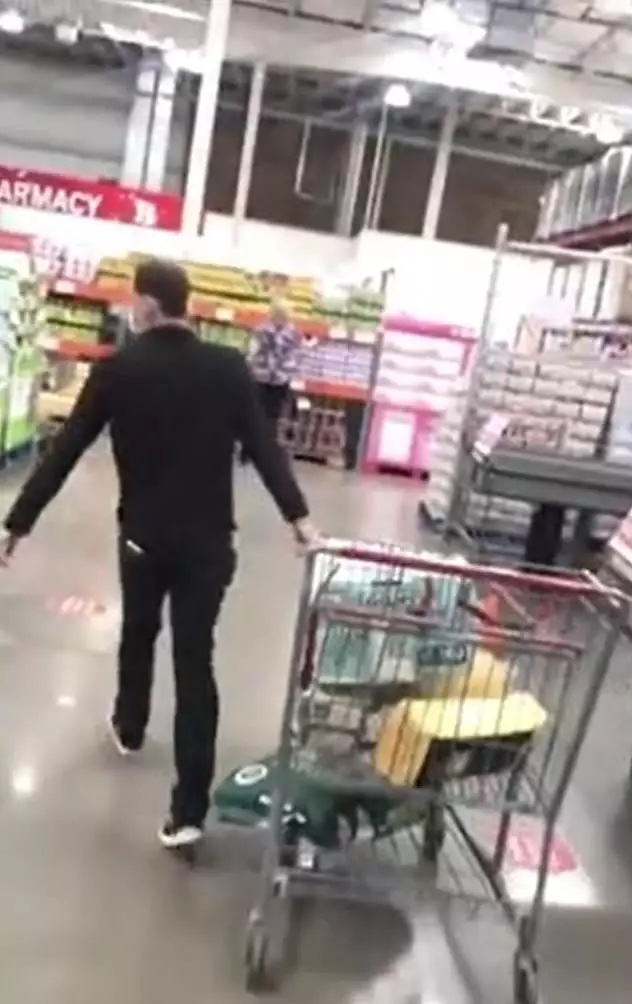 The employee calmly walks away with the shopper's trolley.