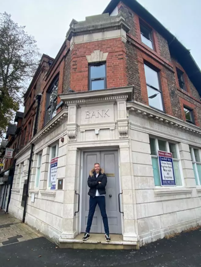 Adam outside the bank building where he was once rejected for a business loan.