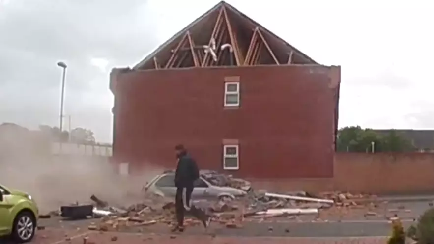 Man Casually Walks Past House As It Crashes Down To The Ground