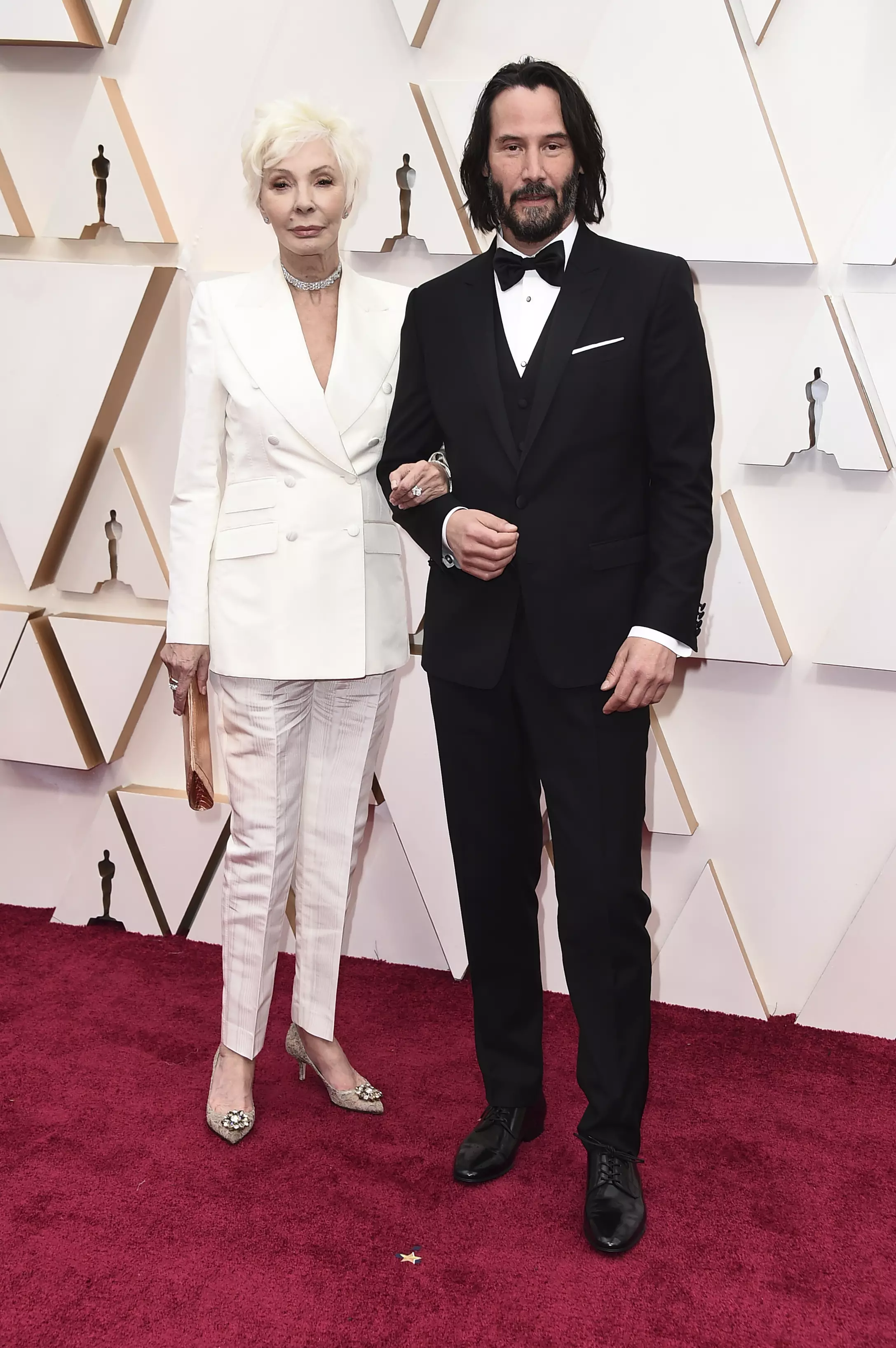 Patricia Taylor, left, and Keanu Reeves arrive at the Oscars.