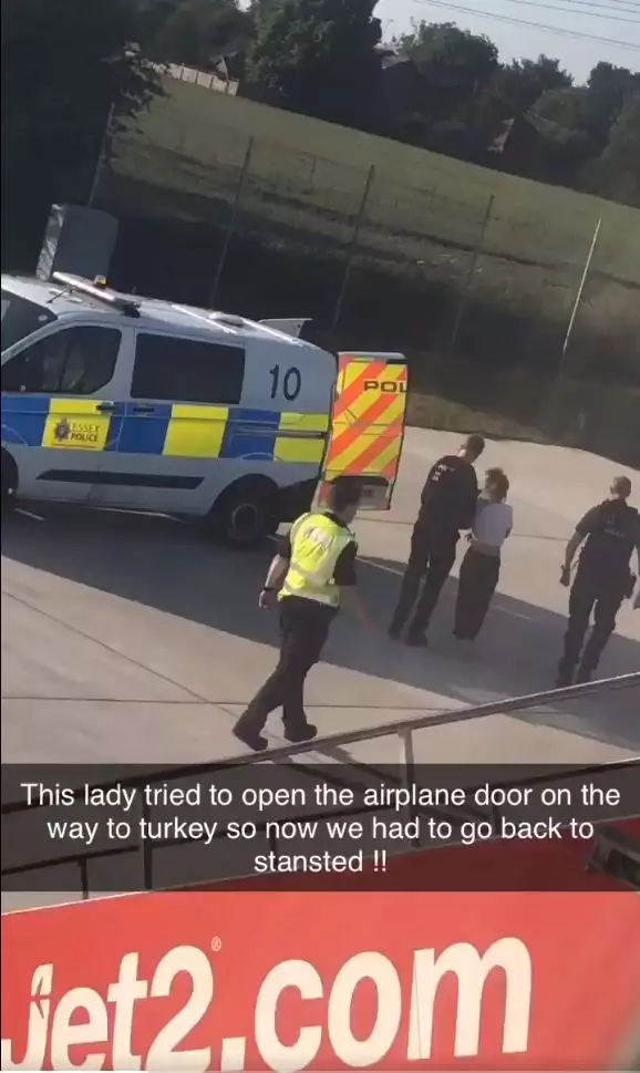 The woman was escorted from the flight by police.