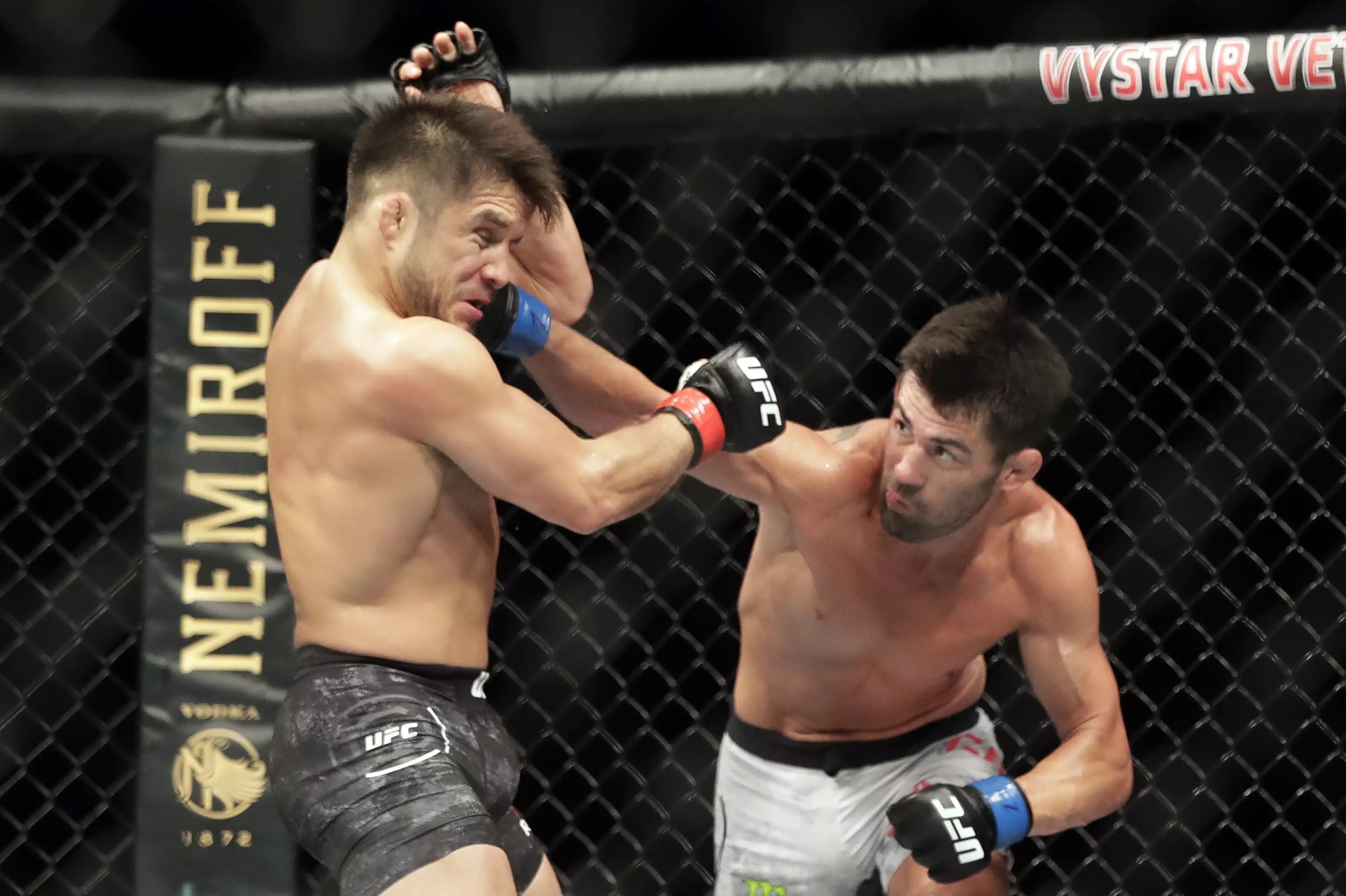 Henry Cejudo, left, takes a firm shot from challenger Dominick Cruz, right, on Saturday night. (Image