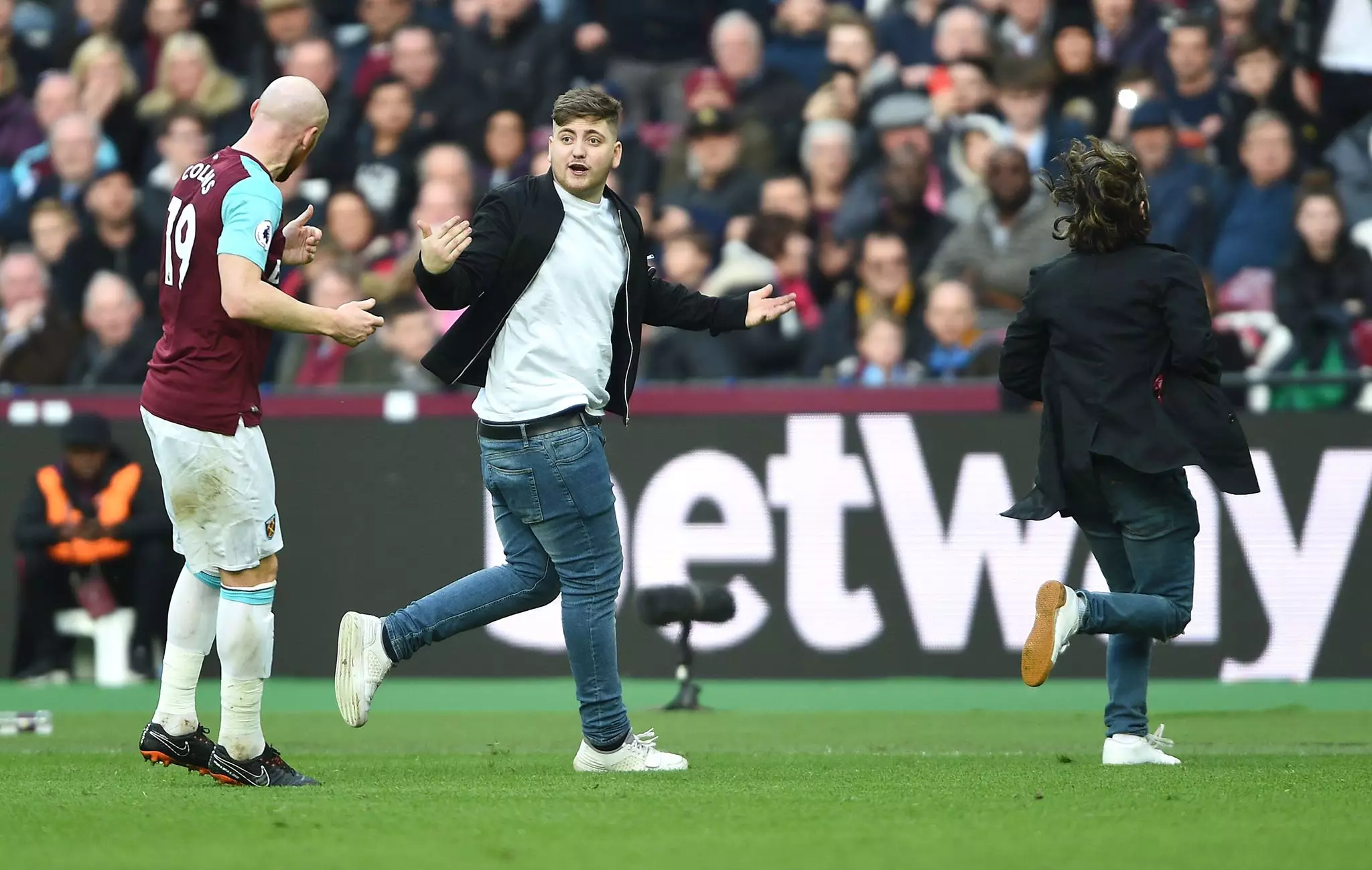 West Ham fans run onto the pitch. Image: PA