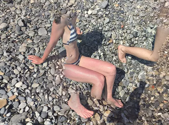 This beach goer's body has merged into the pebbles.