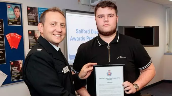 District Superintendent Andrew Sidebotham awarding student Callum with Greater Manchester Police's bravery award.