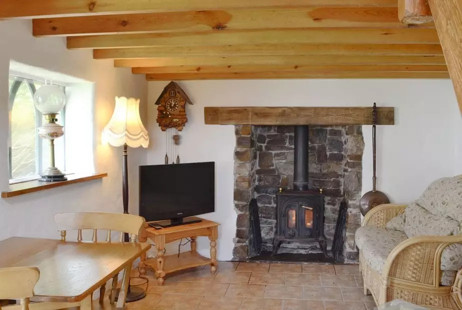 The cosy living room comes with a log burner and grandfather clock (