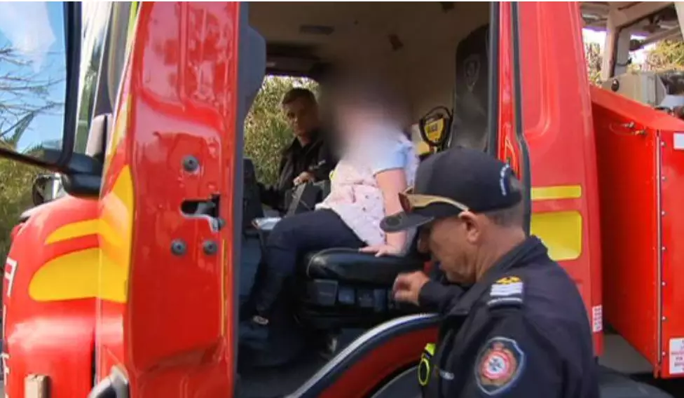 The girl was allowed to ride in a fire truck at an event.