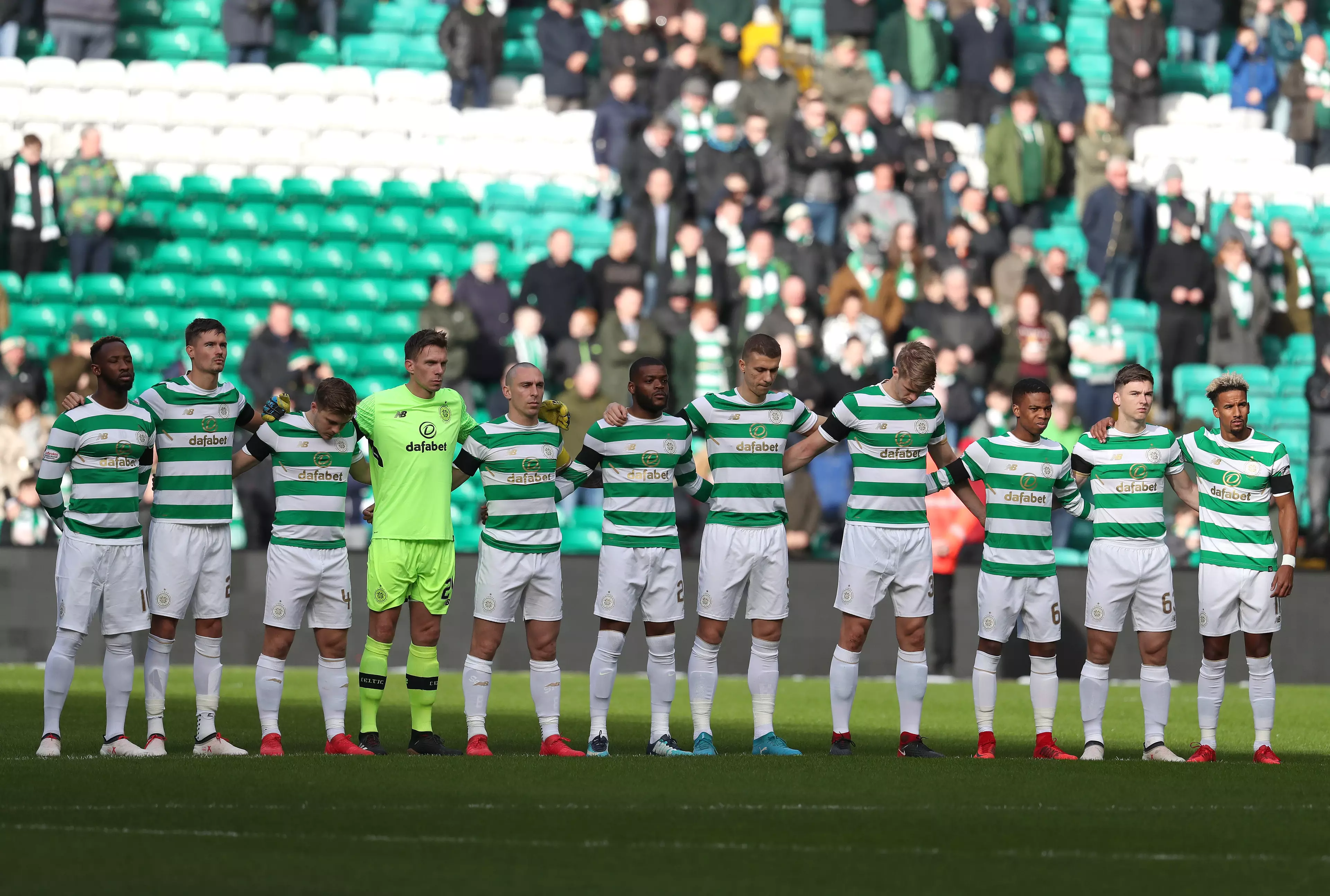 Celtic players stand for a minute's silence in memory of Miller. Image: PA