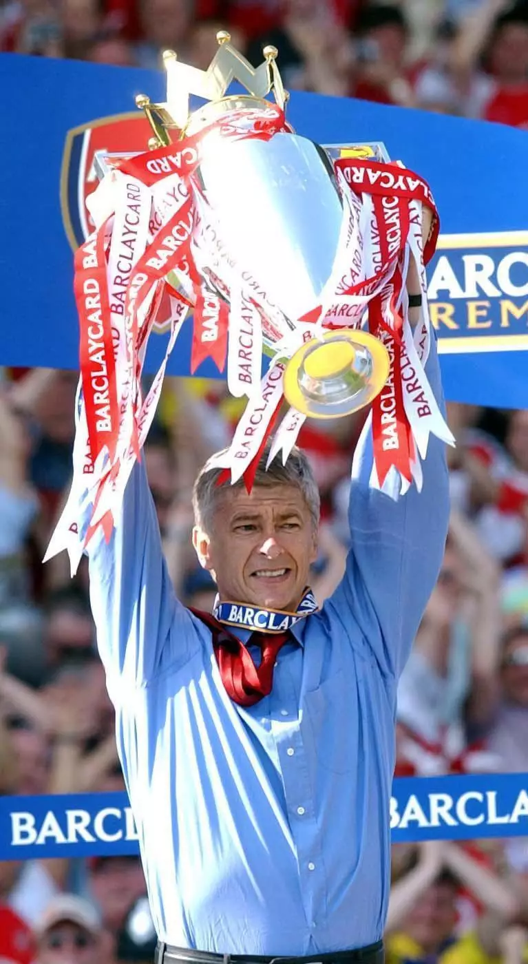 Wenger holding the Premier League trophy after going 38 games unbeaten. (Image