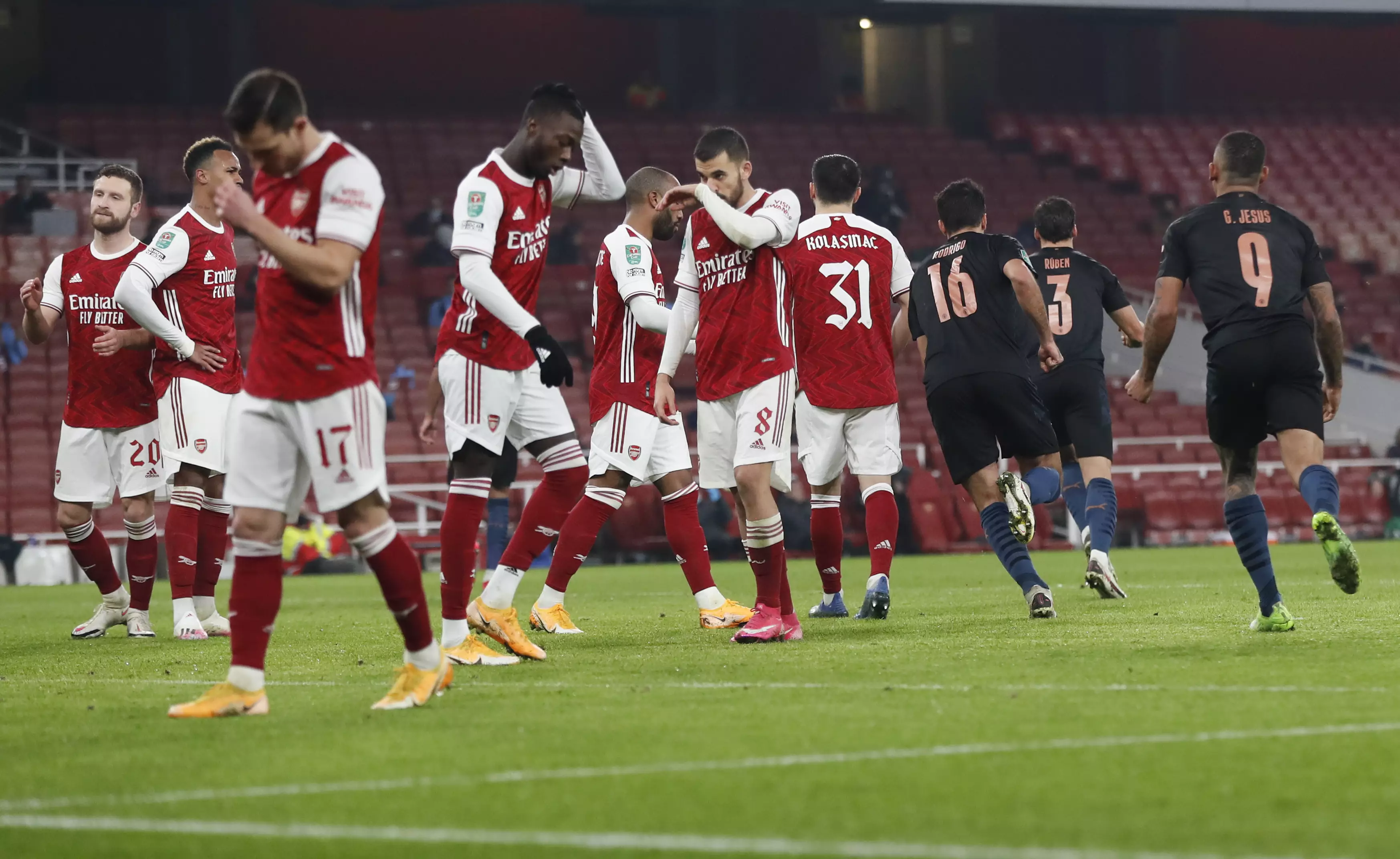 Arsenal players look dejected after conceding against City. Image: PA Images